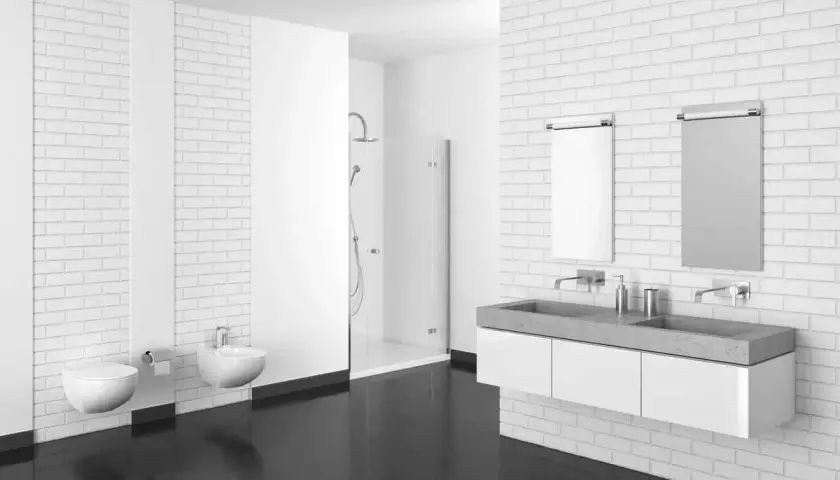 Bagno moderno con pavimenti in resina scura, sanitari sospesi, doccia a scomparsa e doppio lavabo in cemento.