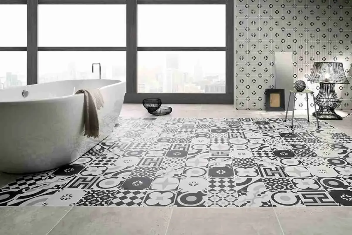 Bagno moderno con vasca freestanding e pavimento decorato con cementine in bianco e nero, che creano un effetto visivo unico.