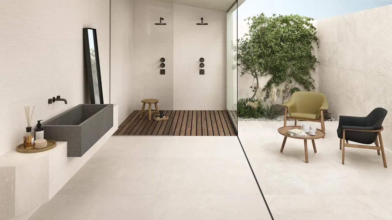 Pavimento casa al mare con vasca in pietra, doccia esterna e zona relax con poltrone.