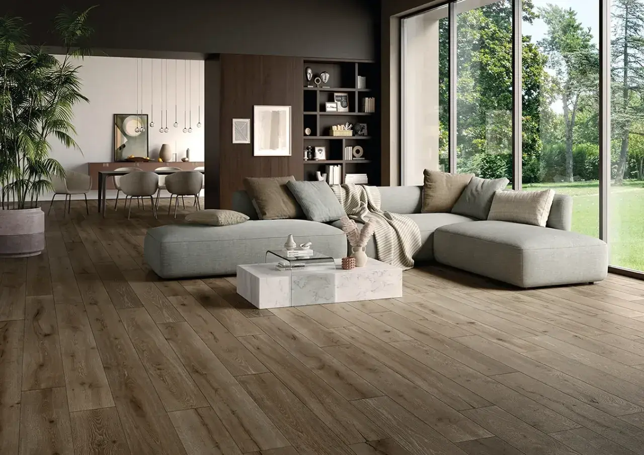 Soggiorno moderno con pavimento in gres porcellanato effetto legno. Abbinamenti eleganti con divano grigio e arredi minimalisti.
