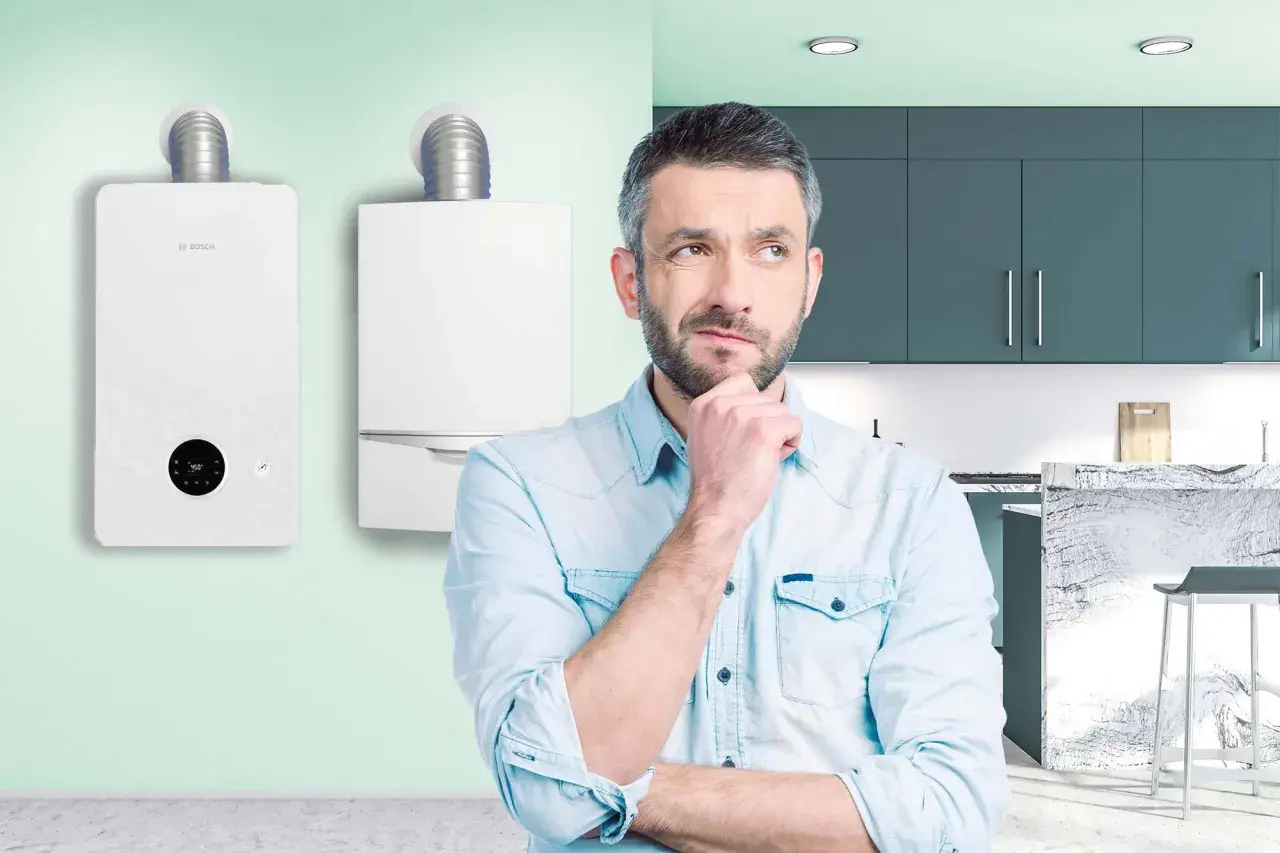 Uomo pensieroso davanti a due caldaie, una delle quali è una caldaia turbo Bosch.
