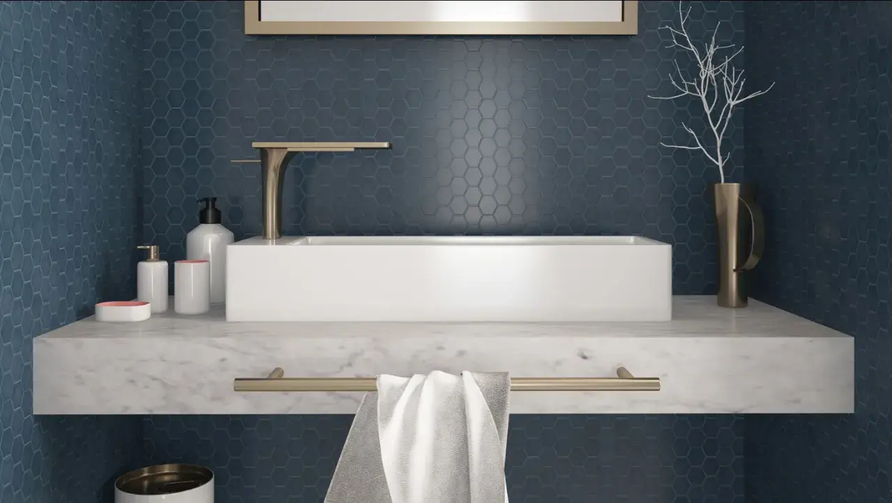 Un elegante bagno con un lavabo rettangolare bianco su un piano in marmo. Le pareti sono rivestite con un bellissimo posa mosaico esagonale blu scuro.