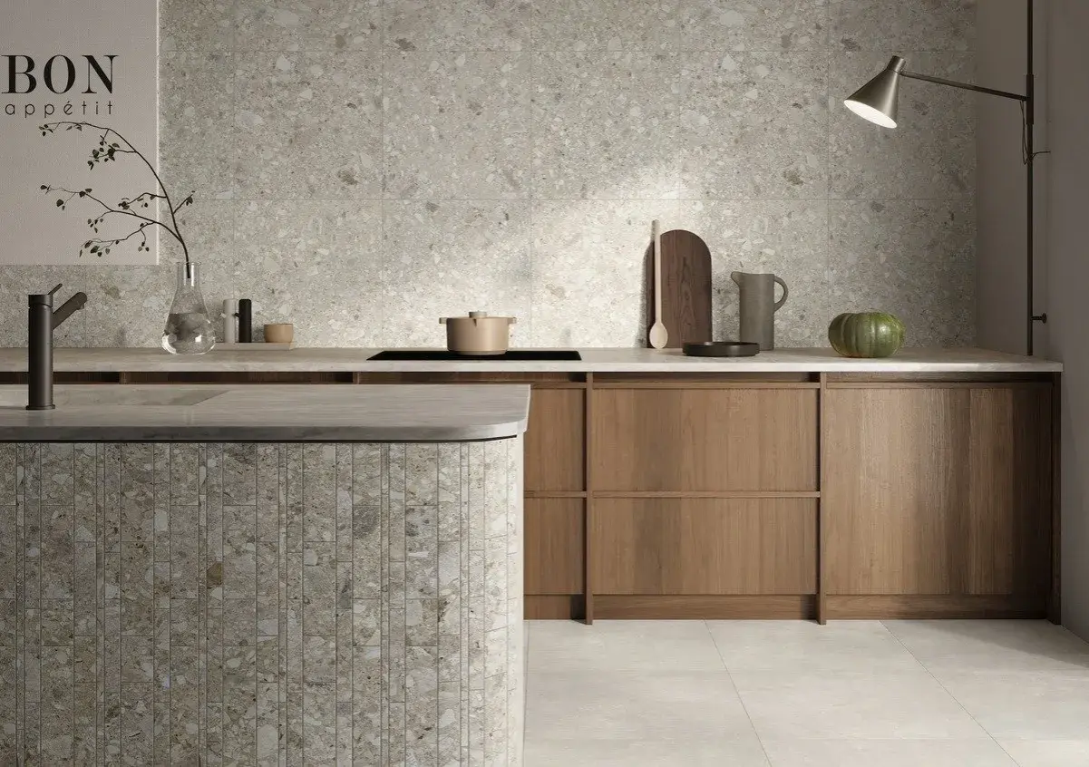 Cucina moderna con isola in **ceppo di gre** e rivestimenti a parete in grès effetto terrazzo.