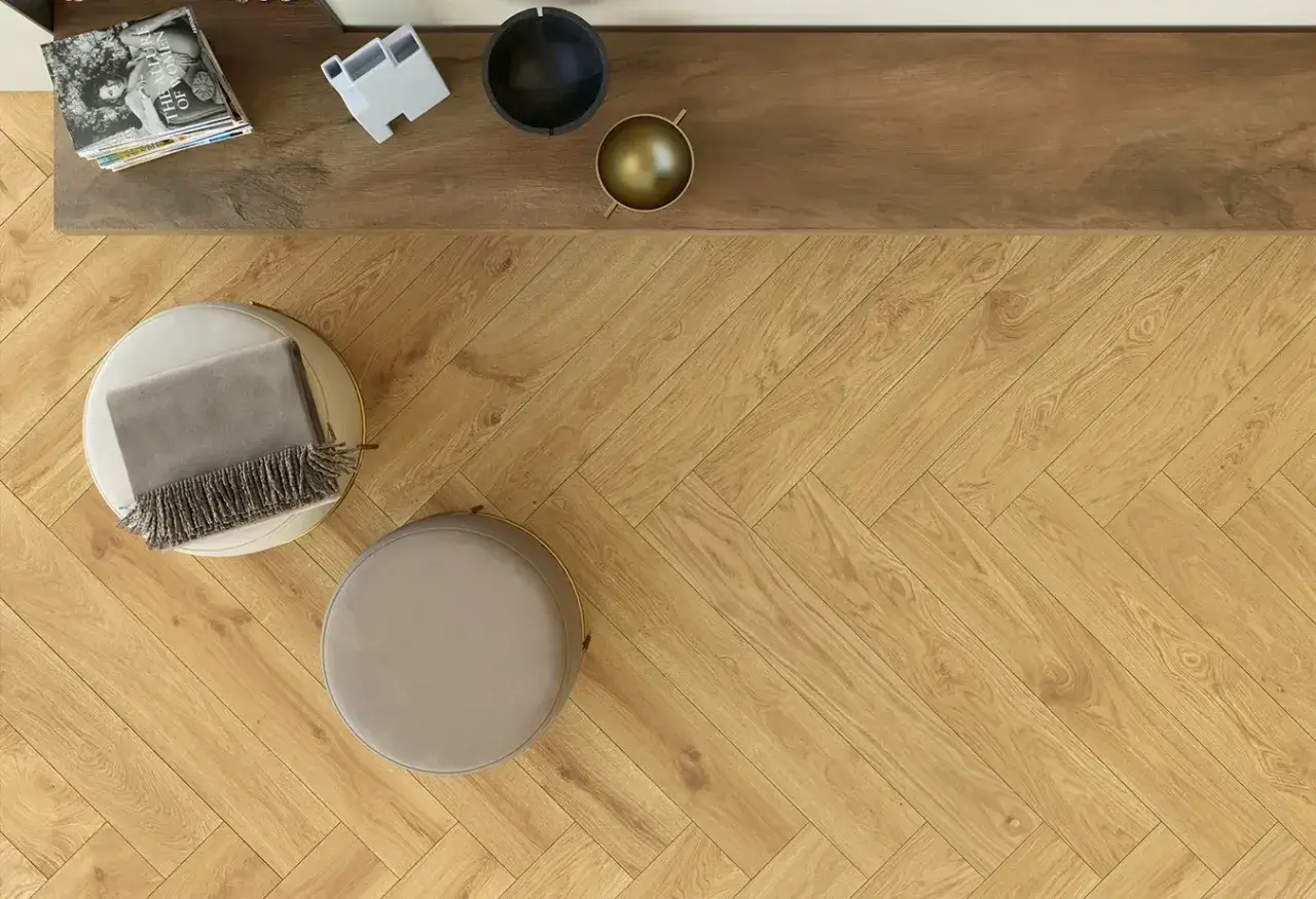 Posa pavimento gres effetto legno a spina di pesce, con pouf e coperta.