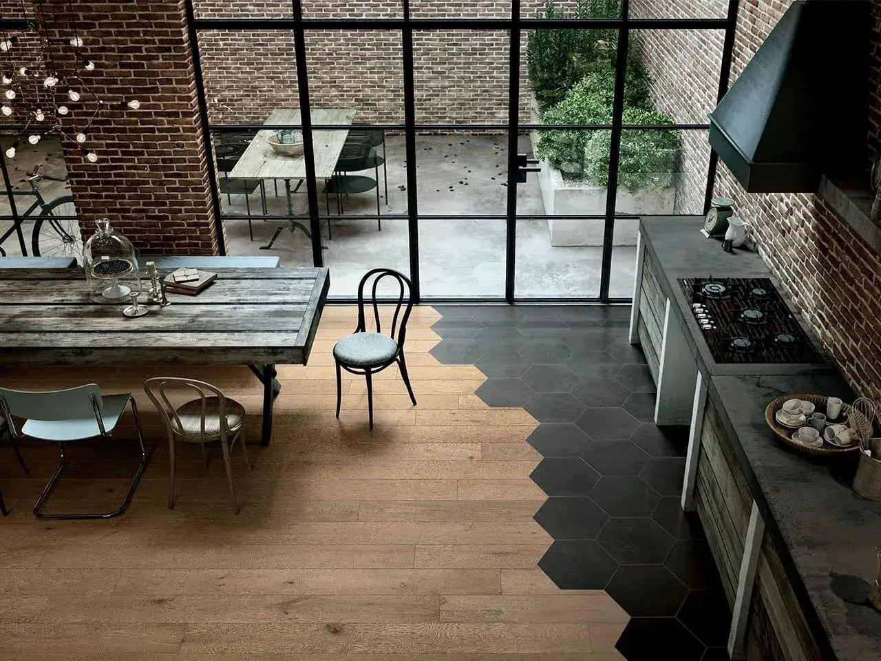 Un'elegante cucina con pavimenti che uniscono il calore del **parquet** e il design moderno delle **maioliche** esagonali scure.
