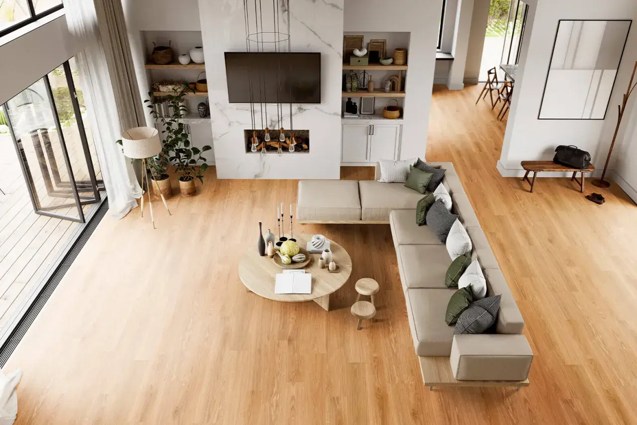 Soggiorno moderno con divano angolare, tavolino rotondo e camino. Il calore del legno dei pavimenti LVT crea un'atmosfera accogliente.