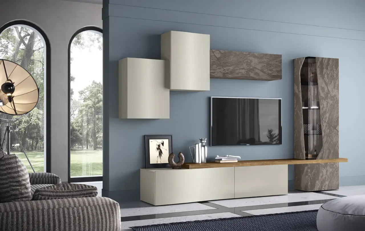 Soggiorno con pareti blu polvere e mobili scuri effetto pietra. Un mobile basso, pensili chiari e una vetrina alta creano un'elegante composizione.
