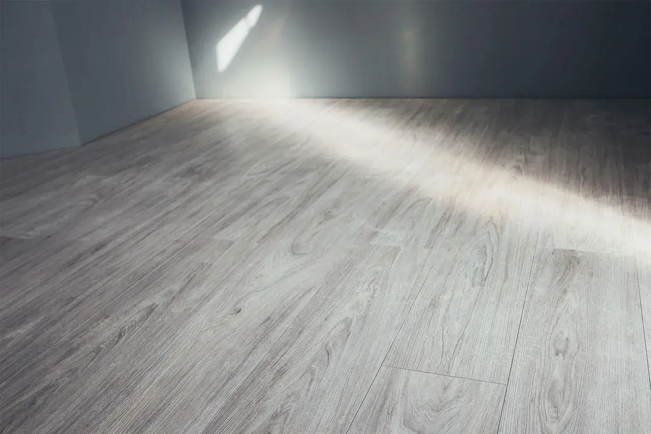 Pavimento in gres porcellanato effetto legno grigio, con luce che filtra dall'alto. Ideale per pulire fughe gres porcellanato effetto legno.