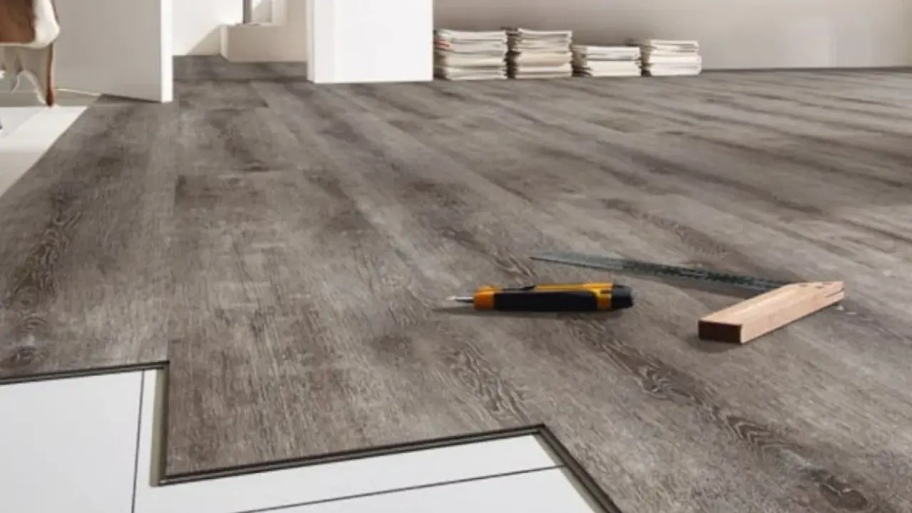 Installazione pavimenti LVT: un taglierino e una squadra pronti per correggere eventuali difetti.