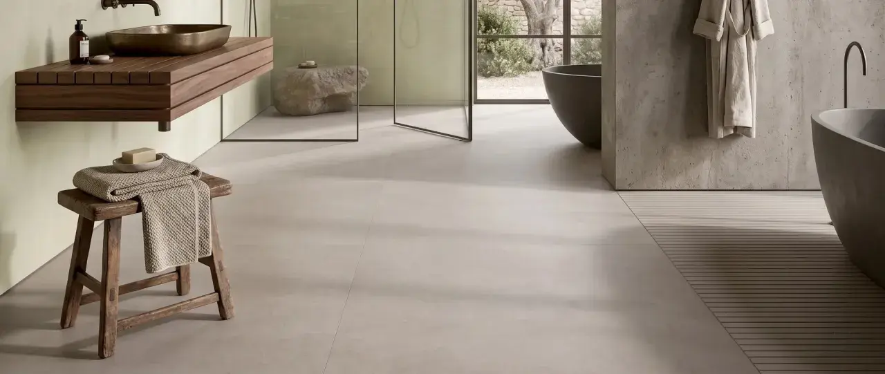 Bagno moderno con gres porcellanato effetto cemento. Pro: stile minimal, facile da pulire. Contro: può risultare freddo al tatto.
