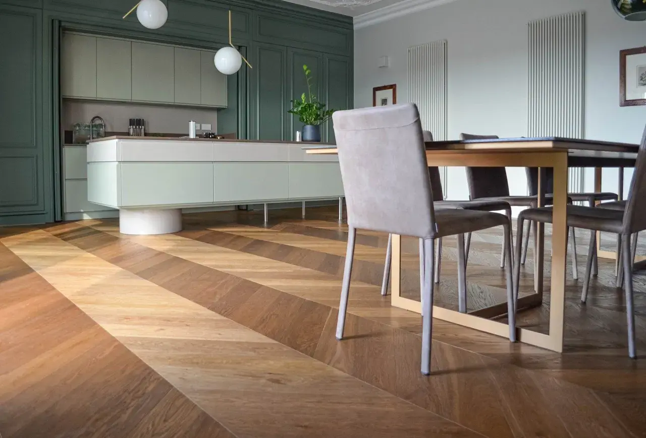 Un elegante soggiorno con cucina moderna e un **miglior parquet** a spina di pesce, che crea un gioco di luci e ombre.