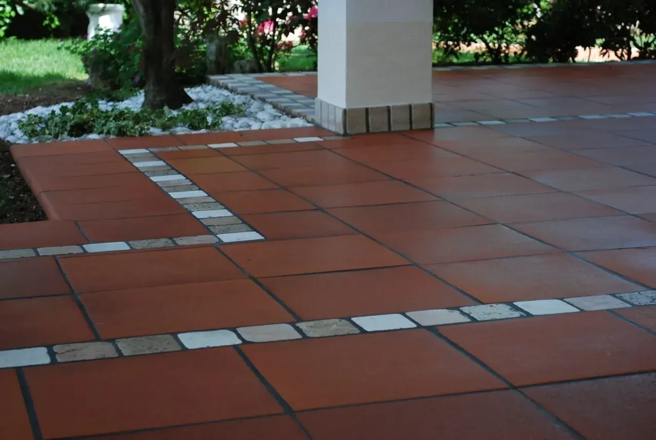 Pavimento esterno in cotto, ideale per pulire pavimento esterno poroso. Dettagli decorativi con inserti in pietra e ceramica.