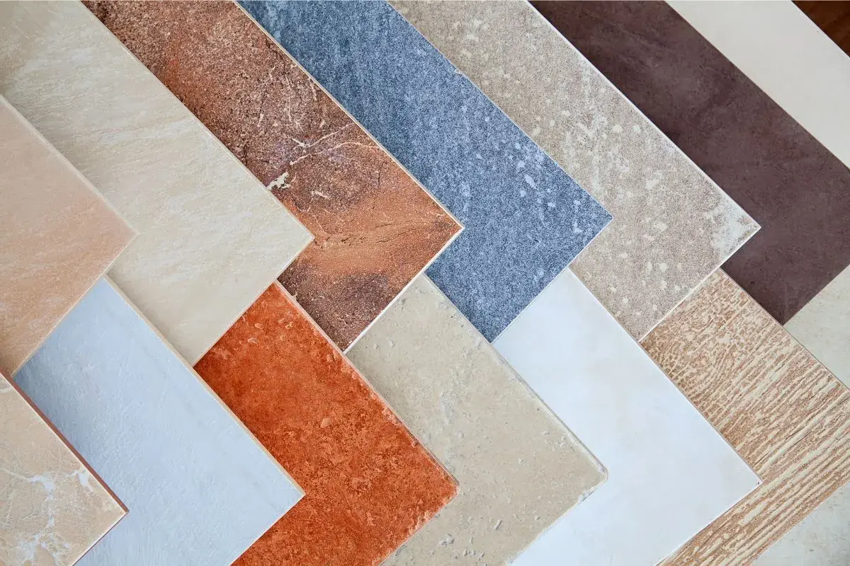 Campione di pavimenti sottili da sovrapporre in varie tonalità e texture, dal beige al marrone, dall'arancione al blu.