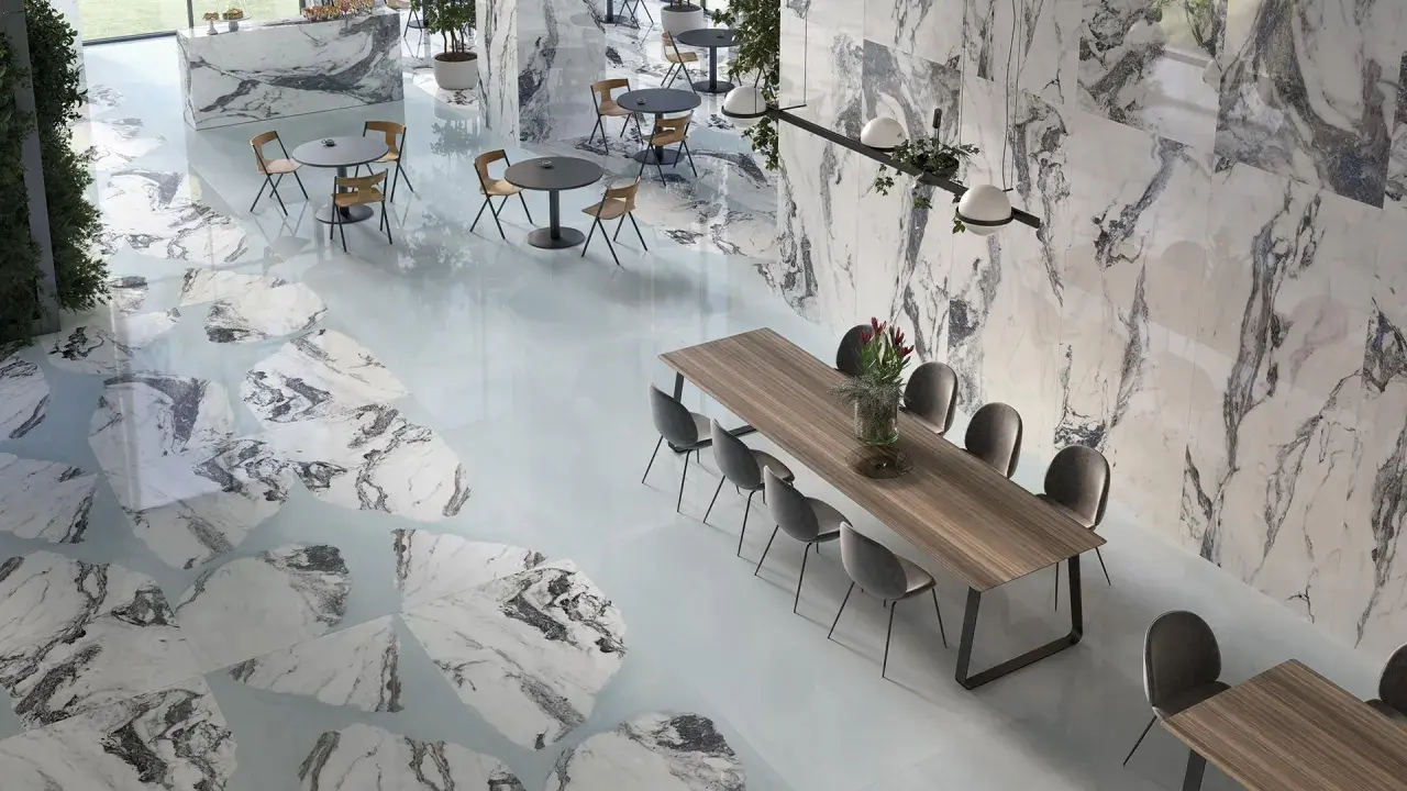 Interni eleganti con pavimenti e pareti che richiamano i **marmo di Carrara colori** con venature grigie e bianche, tavoli e sedie moderne.