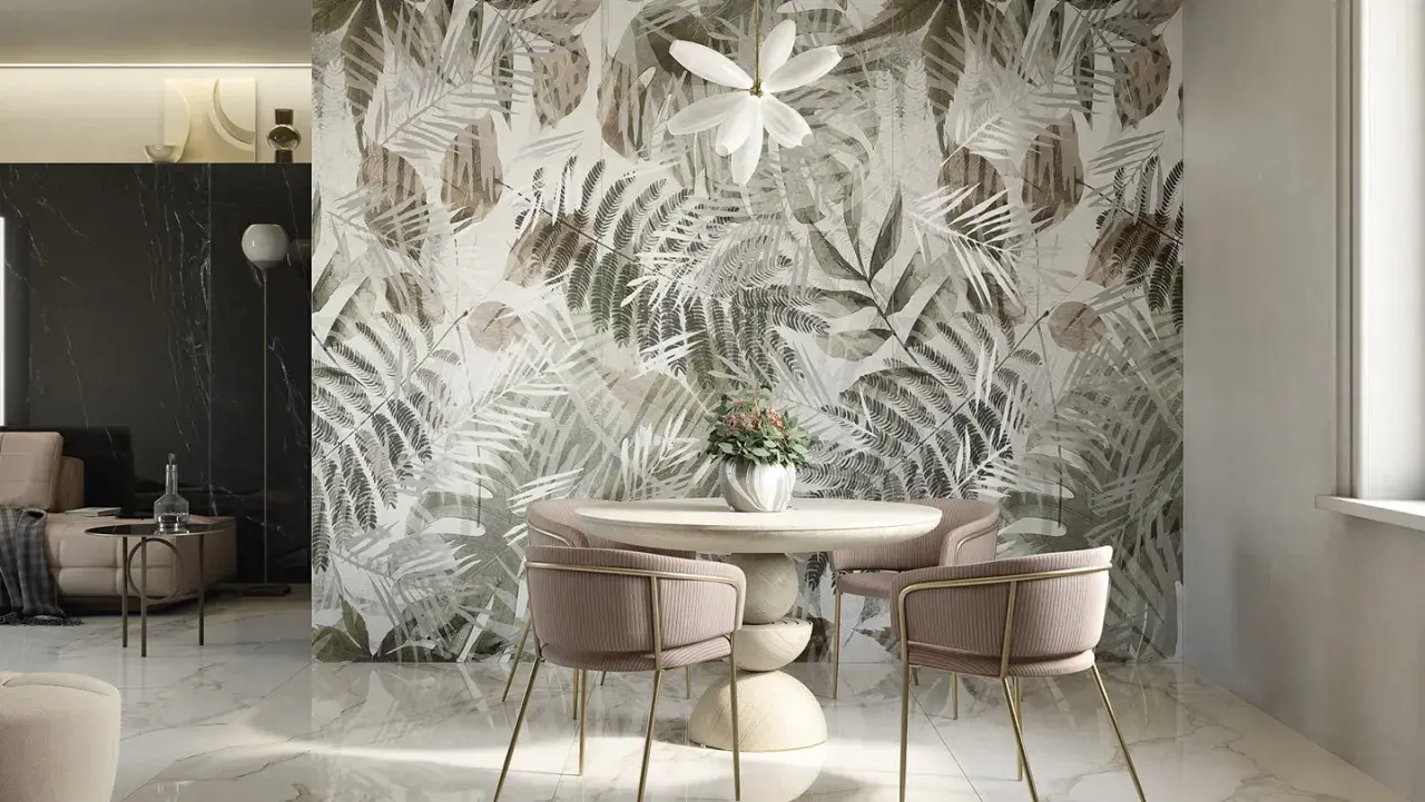 Un tavolo rotondo con sedie rosa e un vaso di fiori davanti a una parete con un motivo botanico. Idee originali per decorare una parete con un tocco tropicale.