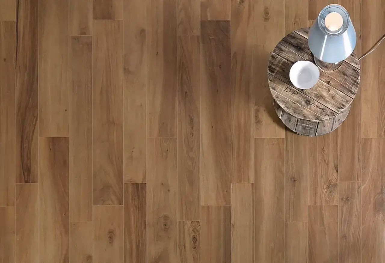 Schema posa gres effetto legno naturale, con tavolino in legno e lampada.
