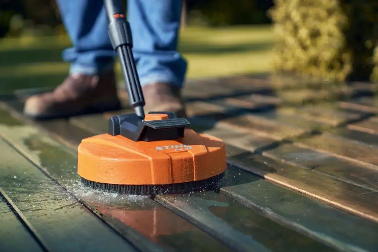 Pulizia pavimenti esterni con idropulitrice Stihl. L'accessorio rotante rimuove sporco e muschio dal legno.