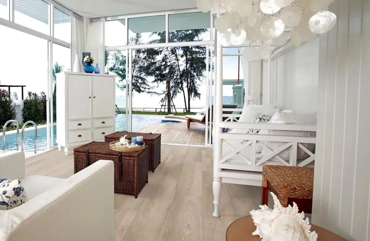 Pavimento casa al mare con vista piscina e spiaggia. Legno chiaro che evoca la brezza marina.