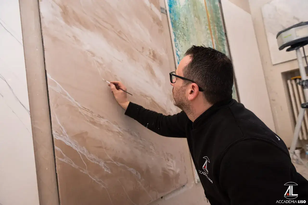 Artista crea un effetto marmo su un pannello, un'alternativa alla rasatura dei muri.