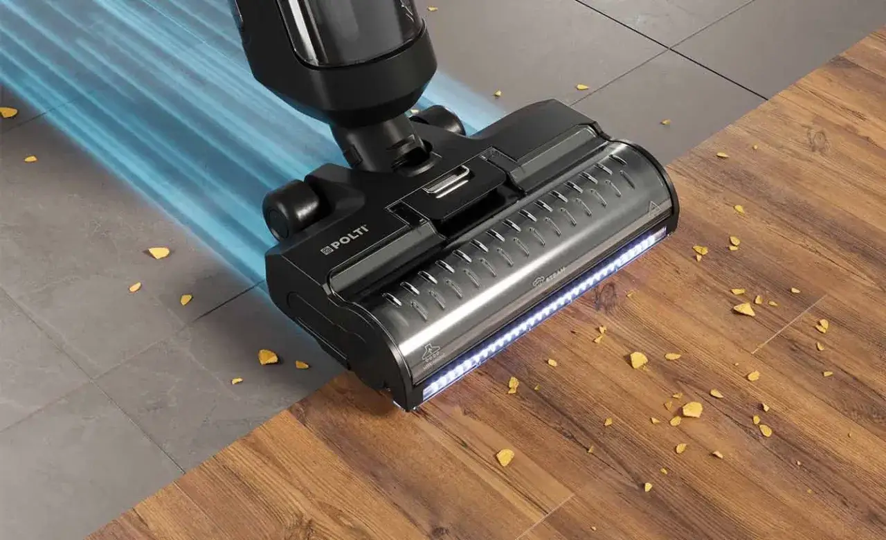 Pulitore a vapore Polti in azione, che mostra come sgrassare il pavimento con efficacia, aspirando detriti su piastrelle e parquet.