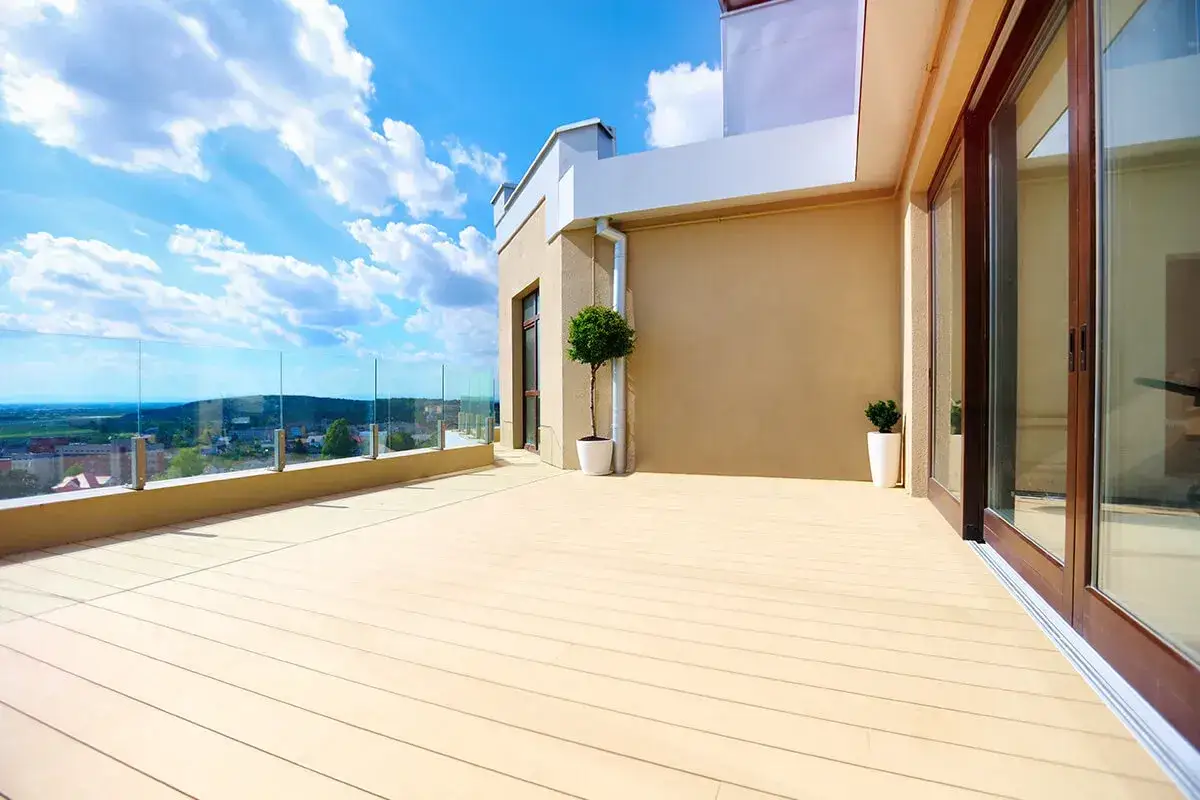 Ampia terrazza con pavimento galleggiante per esterni, ringhiera in vetro e vista panoramica.