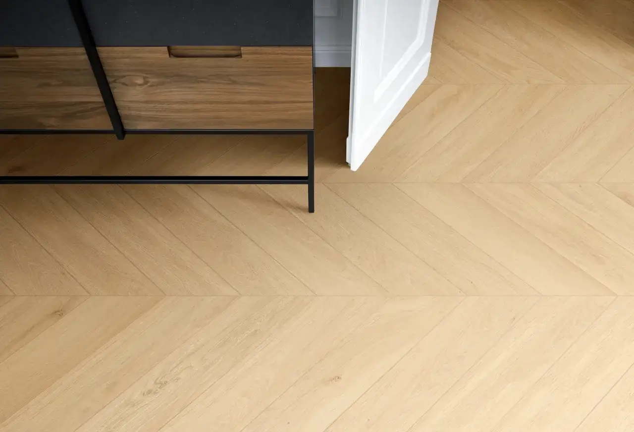 Un elegante pavimento in gres laminato a spina di pesce, con un mobile moderno in legno e metallo.