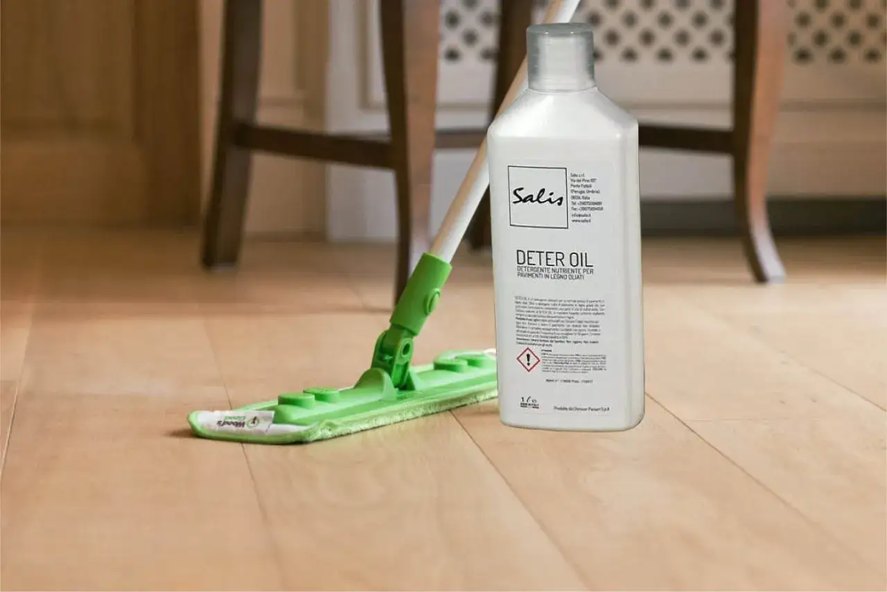 Mocio verde e flacone di Deter Oil per la pulizia del parquet.