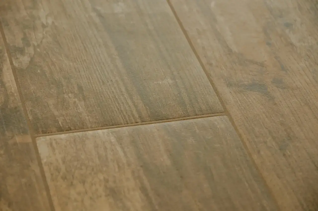 Dettaglio di piastrelle in gres effetto legno con fughe sottili e color sabbia, che colore fughe gres effetto legno per un look naturale.