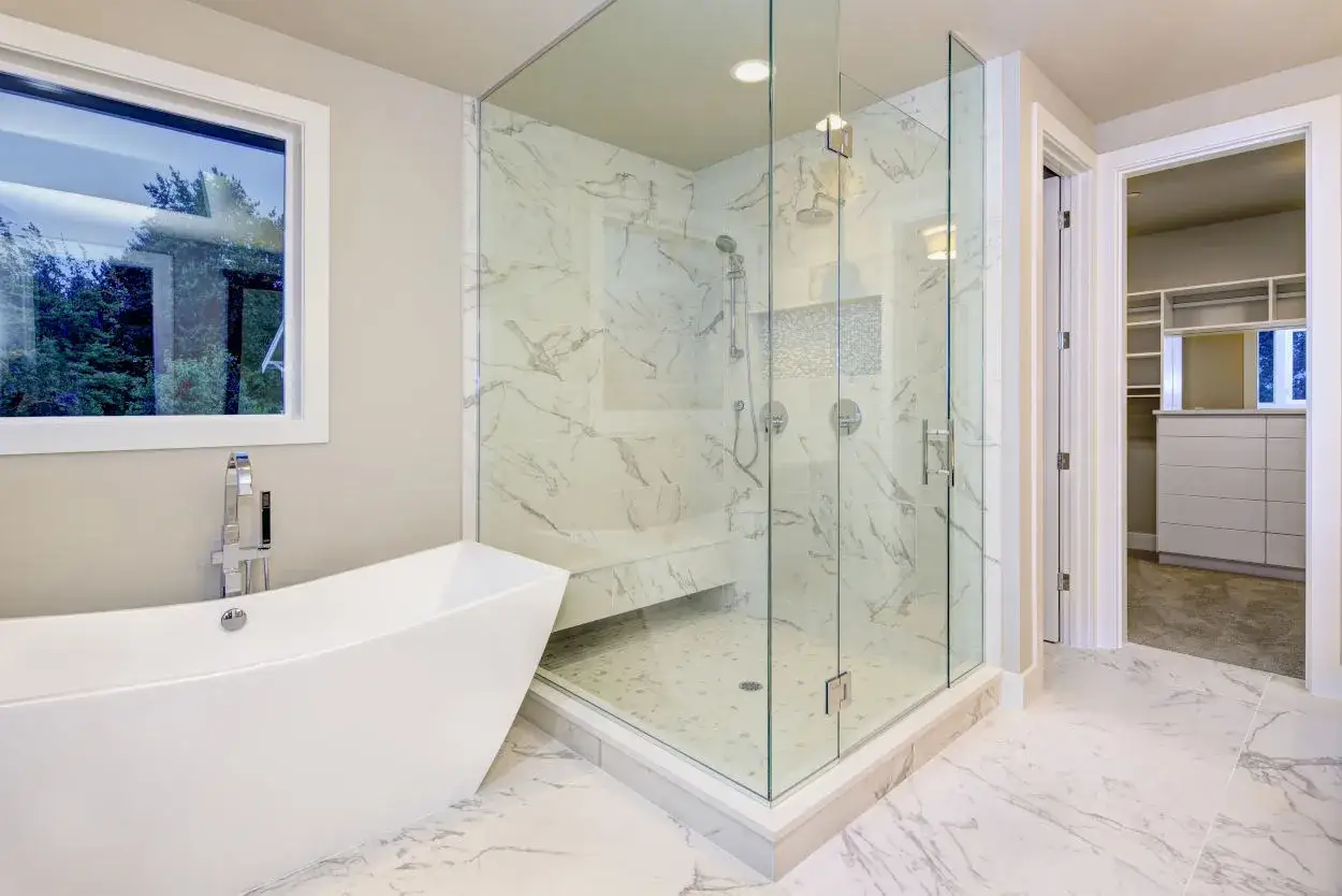 Bagno moderno con vasca freestanding e doccia con pareti in vetro. Il piatto doccia, con mosaico a pavimento, è il miglior materiale piatto doccia per un look elegante.