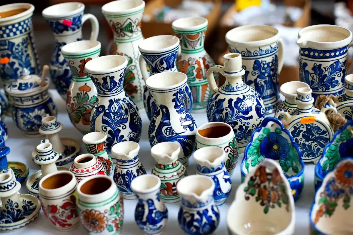 Una ricca collezione di ceramiche artigianali, vasi, brocche e piccole brocche decorate con motivi blu e bianchi, che raccontano la storia della ceramica.