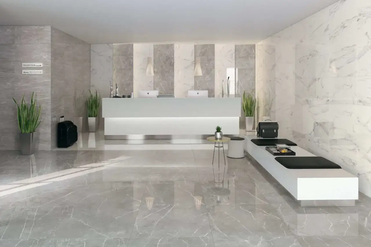 Lobby moderno con pavimenti in marmo lucido e pareti a contrasto. La reception bianca è illuminata da luci soffuse.