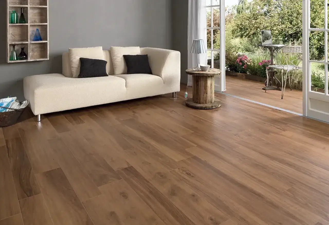 Un soggiorno moderno con divano bianco e domus pavimenti effetto legno che si estendono verso un giardino lussureggiante.