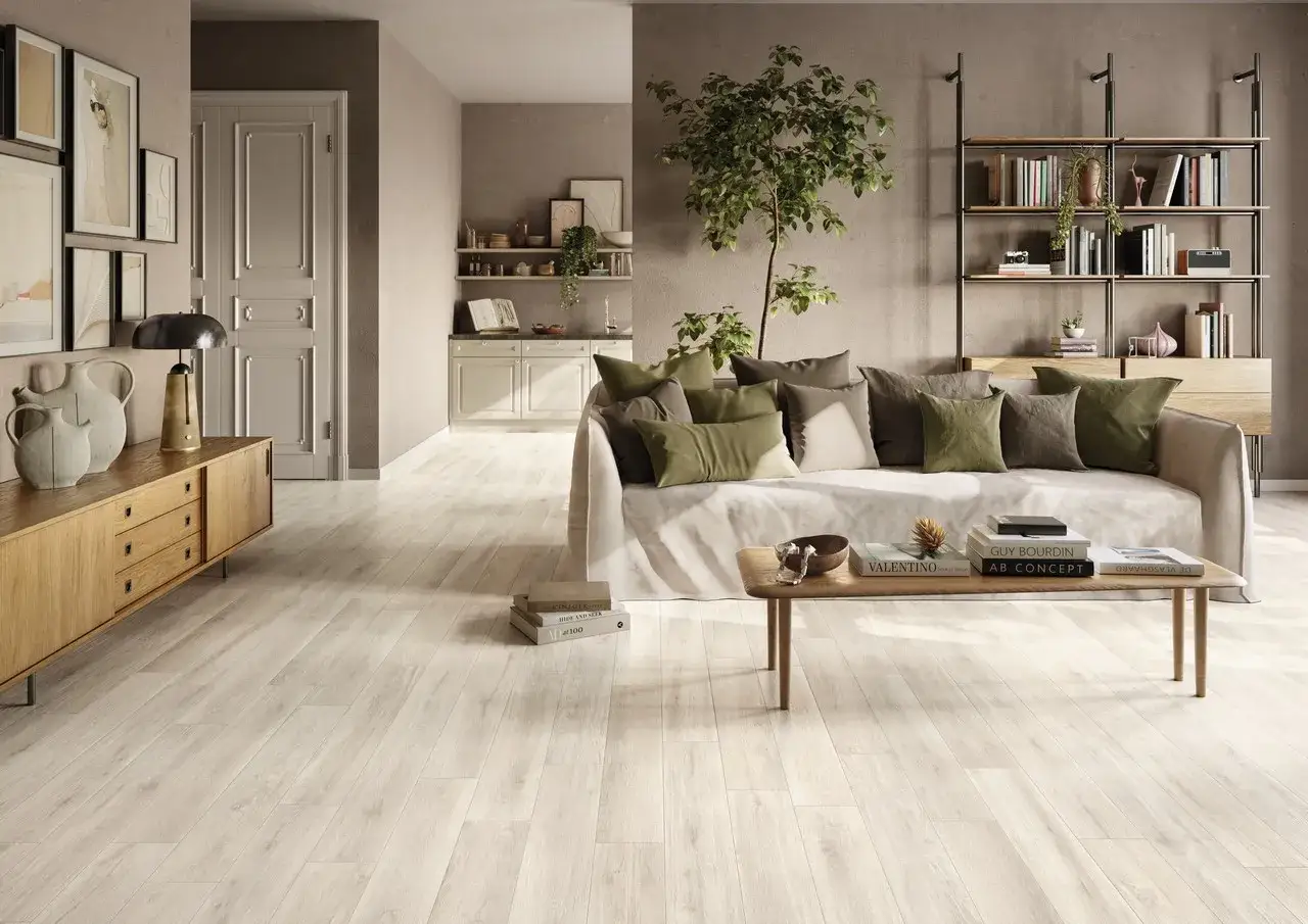 Soggiorno moderno con pavimento effetto legno chiaro, tra le ultime tendenze pavimenti interni. Divano comodo, tavolino e libreria completano l'arredo.