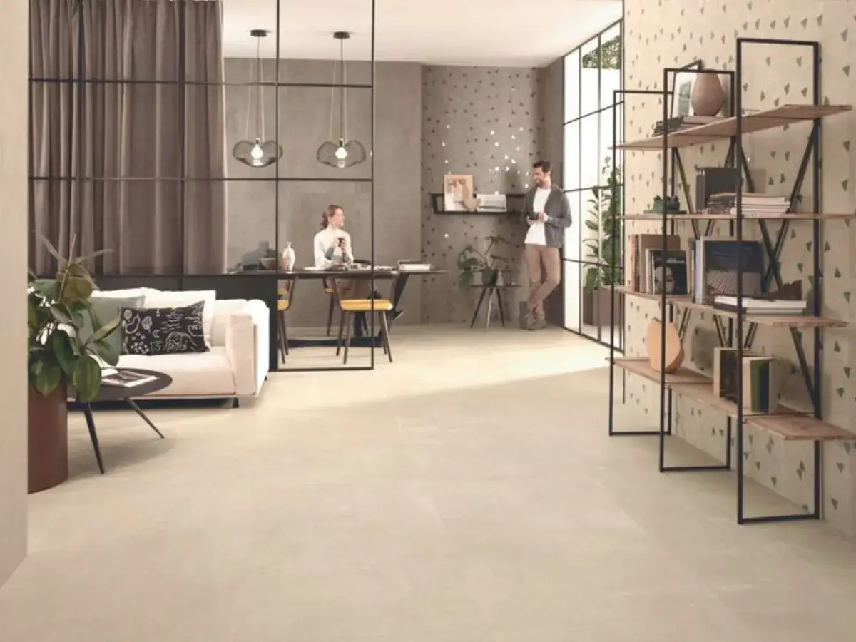 Soggiorno moderno con divano bianco, scaffali in legno e pareti decorate. Le fughe piastrelle non rettificate del pavimento creano un effetto continuo e armonioso.