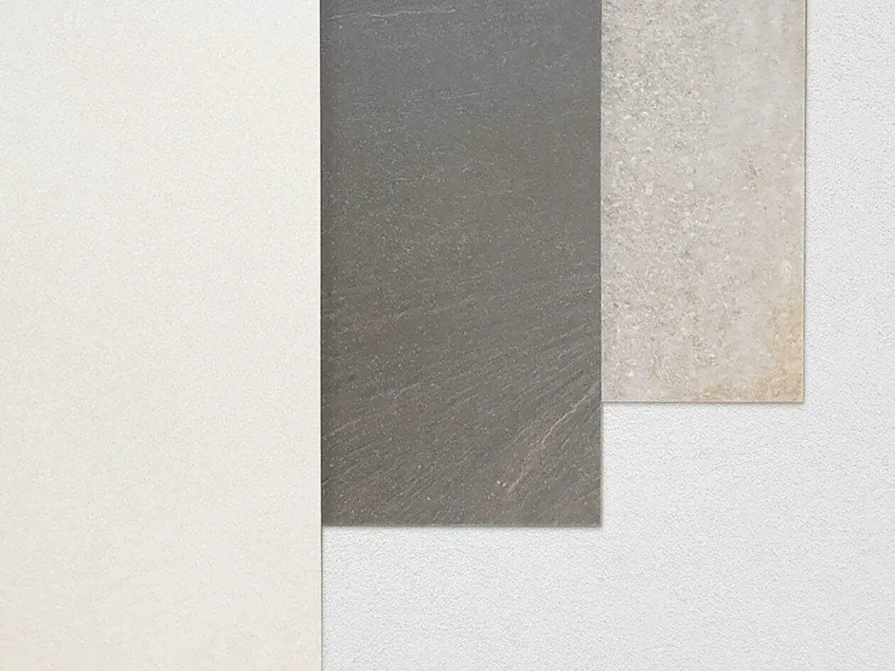 Tre campioni di piastrelle rettificate: bianco, grigio ardesia e beige effetto pietra. Fuga minima per un look moderno.