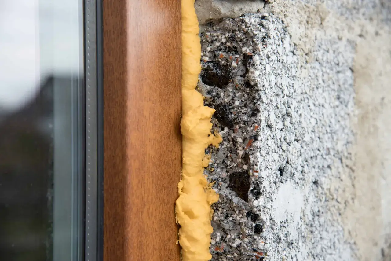 Installazione finestra: schiume poliuretaniche isolano il telaio in legno dal muro grezzo, garantendo efficienza energetica.