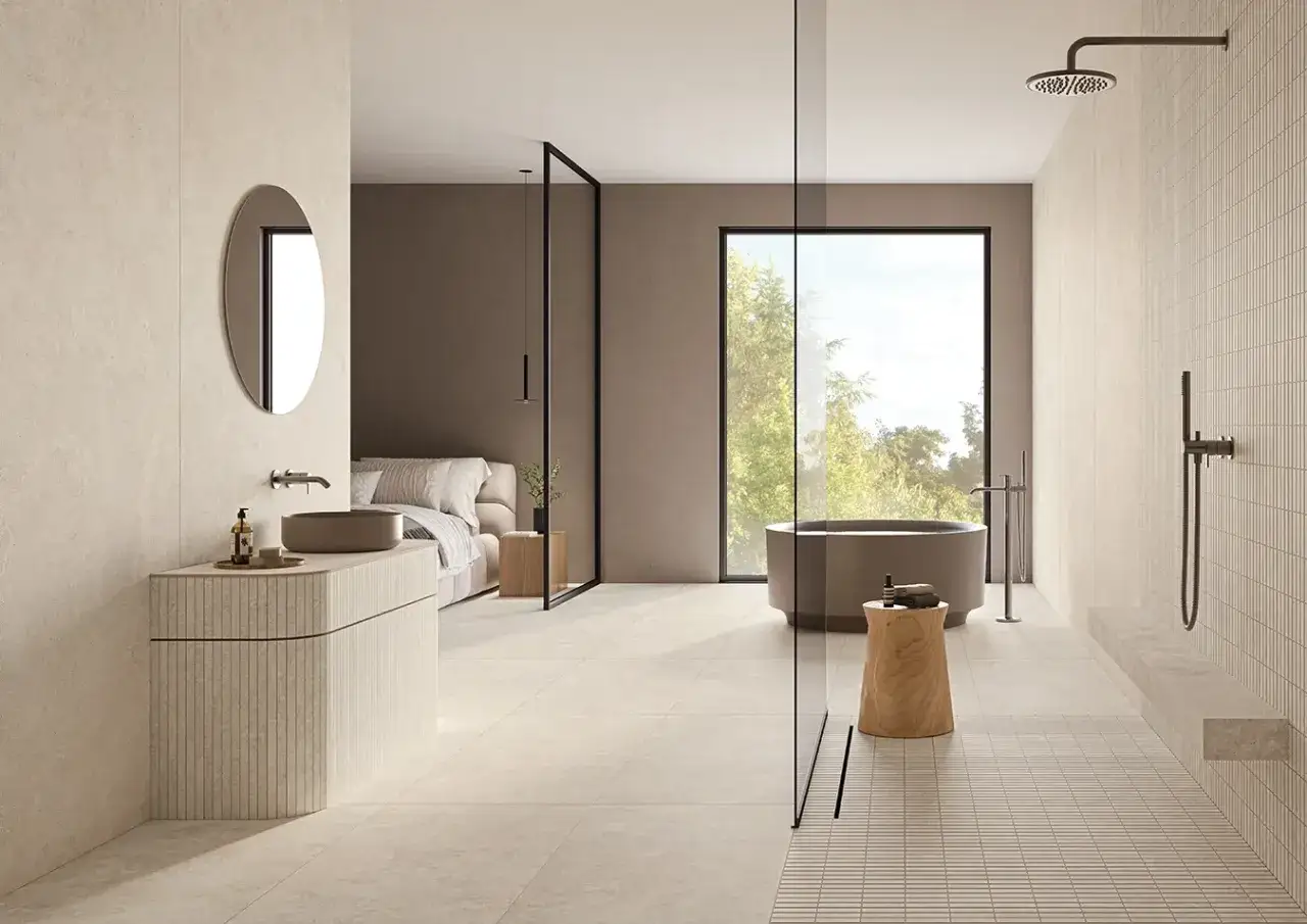 Bagno moderno con vasca, doccia e letto visibili. Il pavimento chiaro moderno crea un'atmosfera rilassante e luminosa.