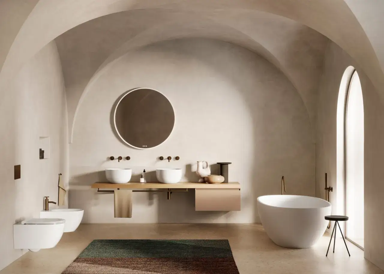 Bagno moderno con sanitari sospesi, vasca freestanding e rubinetteria in ottone. Arredo essenziale e raffinato.