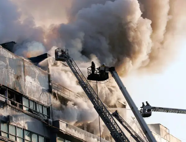 Vigili del fuoco da piattaforme aeree combattono un incendio in un edificio, dimostrando che la lana di roccia è ignifuga.