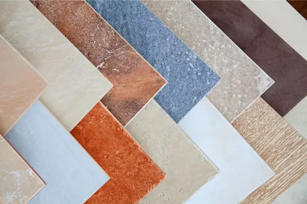 Campione di pavimenti sottili da sovrapporre in varie tonalità e texture, dal beige al marrone, dall'arancione al blu.